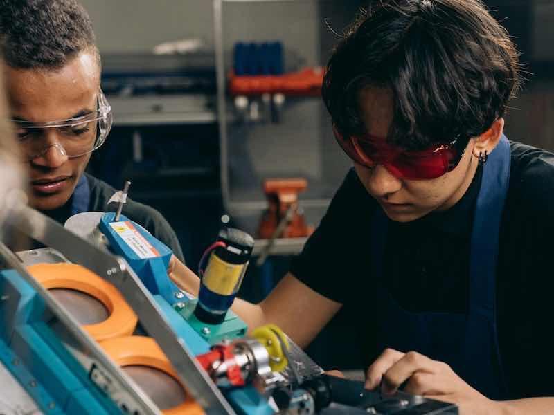 two people working on parts