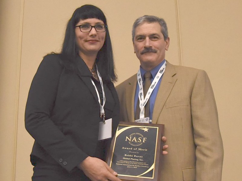 two people standing receiving award