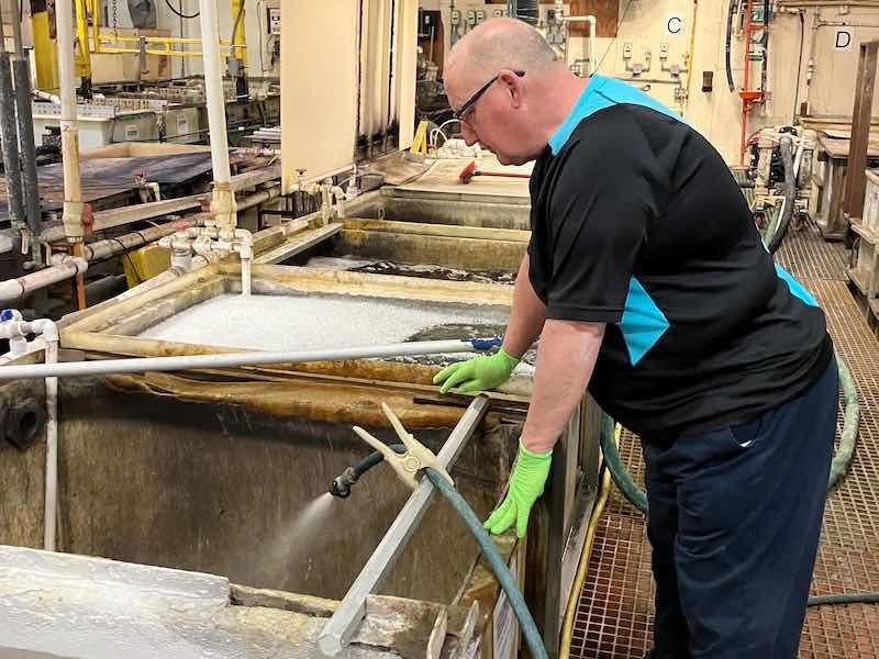 man looking at plating tank