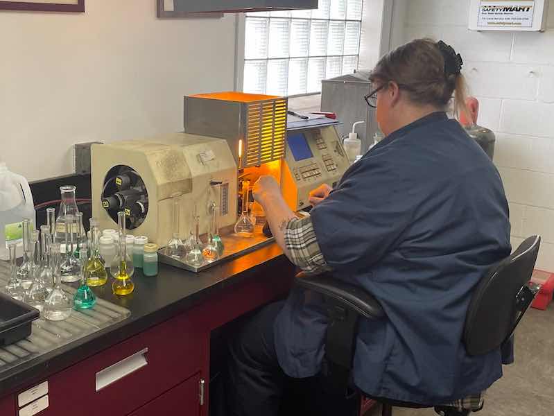 Klusman working at her lab at Reliable Plating Works, testing plating tanks.