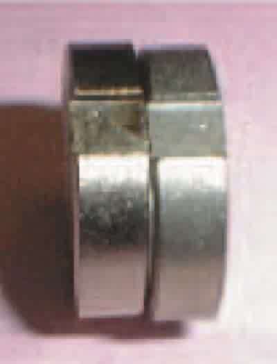 This part has been electroless nickel-plated and has a stain on the right side of the notched area (after a one-hour boil in deionized water). The part on the right is an unplated sample submitted along with the plated sample.