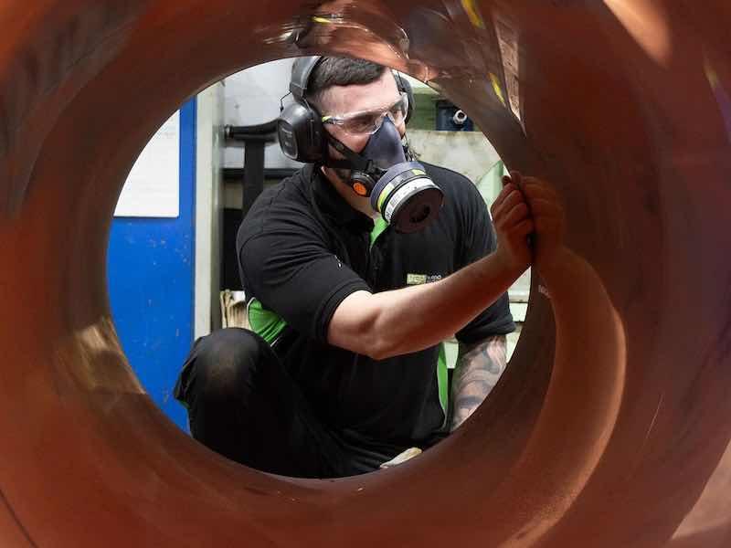 man looking through coated pipe