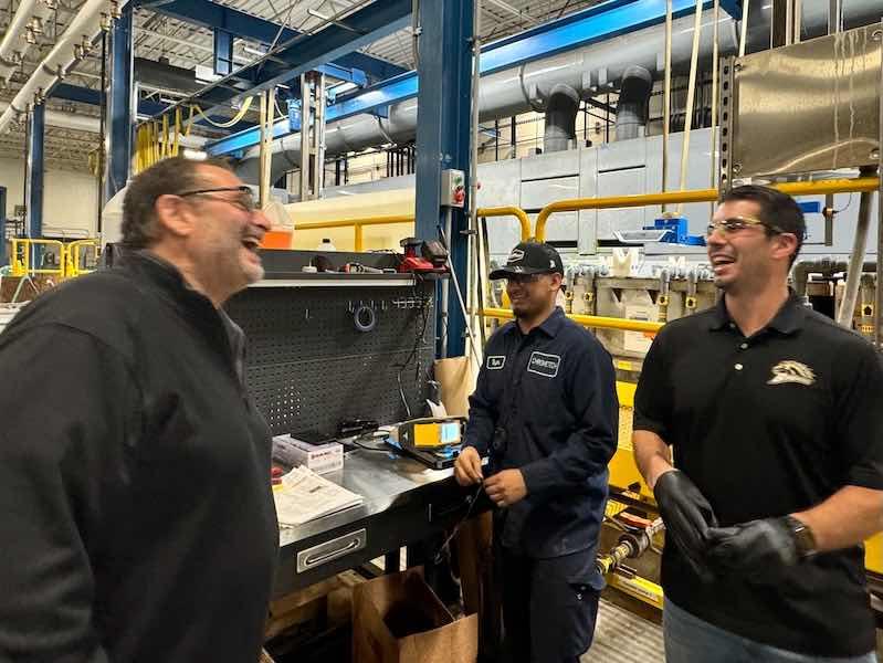 Alan Henry, left, and Ross Henry, at right, share a laugh while on the shop floor at ChromeTech of Wisconsin.