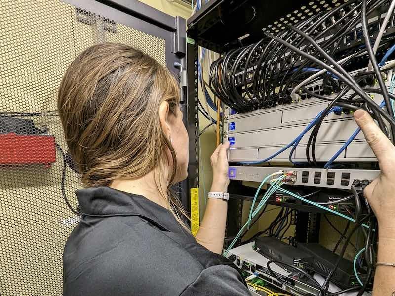 woman adding wires to computer system
