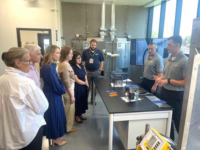 people in a lab looking at someone speaking