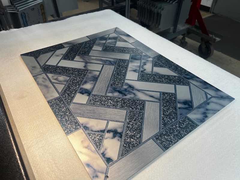 After removing the part from the anodizing tank, it is rinsed and then dried to prepare it to receive the image, which is printed using specialized sublimation inks and papers so that the inks that comprise the image will sublimate onto the part, where the inks will flow into the pores in the anoxic surface.