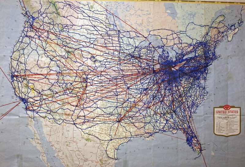 Map in Dr. Lindsay's home with the blue showing U.S. highways he has driven, and the red for flights to cities.
