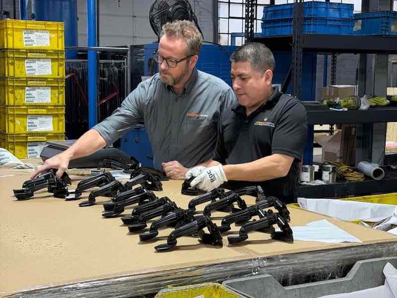 CEO Stephen Walters works with a staff member in reviewing parts.