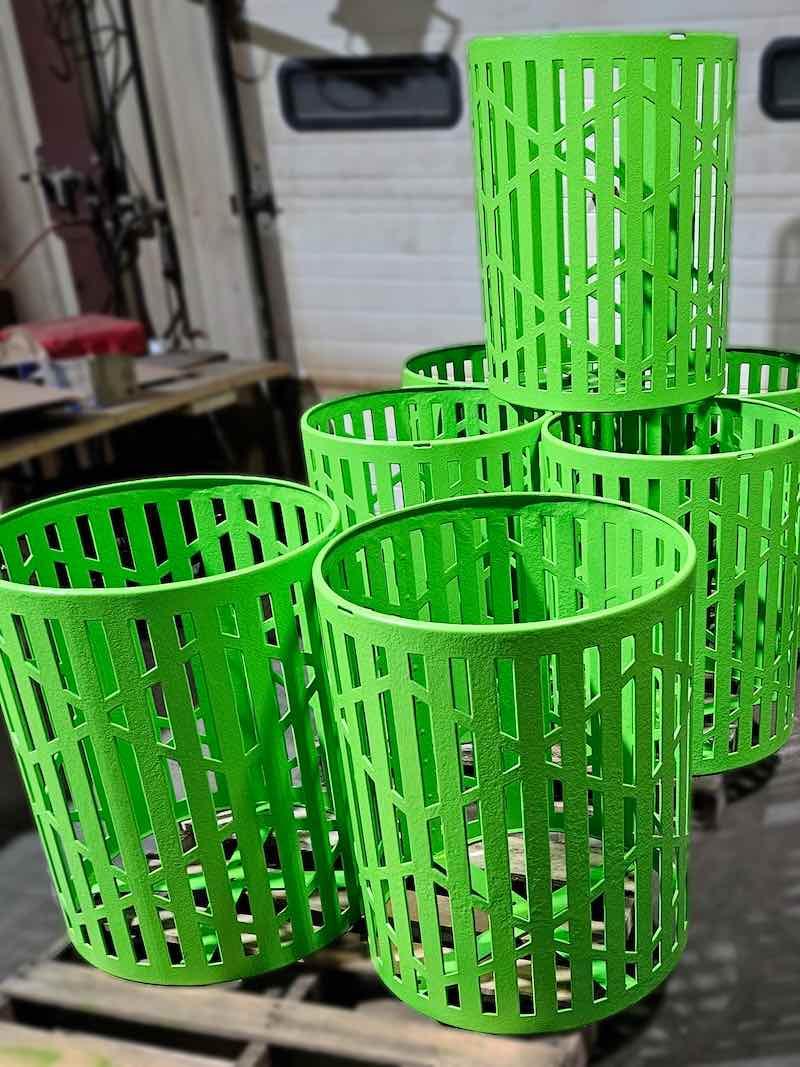 Powder coated trash cans await shopping to a park service.