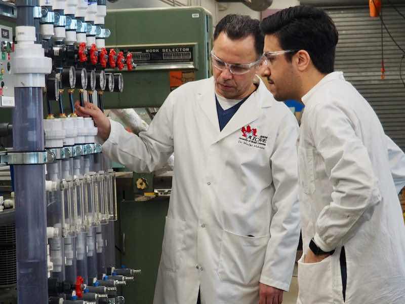 Professor Madjid Mohseni and postdoctoral fellow Dr. Ehsan Banayan Esfahani looking at a pilot water treatment system that will be deployed in British Columbia in April