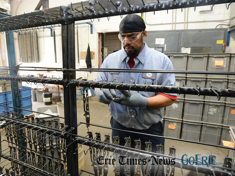 Dana Bell, line operator, prepares auto parts to be plated at Great Lakes Metal Finishing Inc. in Erie. [JACK HANRAHAN/ERIE TIMES-NEWS]