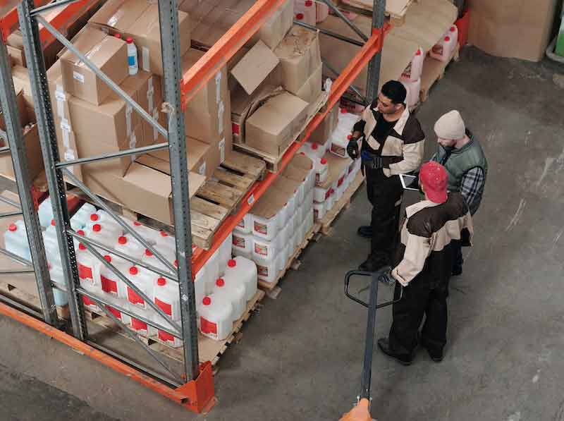 men in warehouse looking at supplies