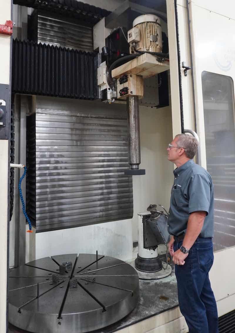 Brockman inspects a new machine that gives Techmetals added grinding capabilities, including a five-axis machine available for its chrome work.