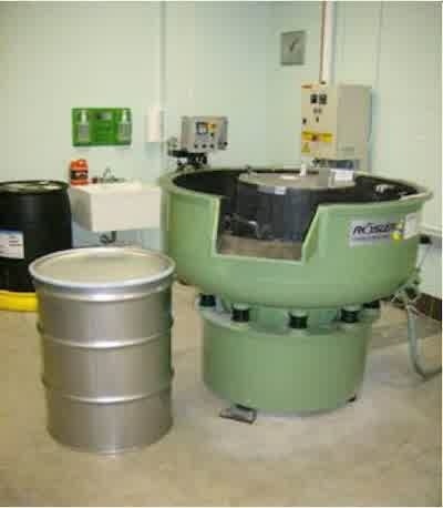 Figure 1 - Large vibratory bowl with 1.16 m inner diameter and a dosing station in the background for continuous flow of chemicals through the bowl.
