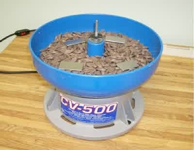 Figure 3 - Small vibratory bowl with 0.28 m inner diameter filled with 2.2 L of large ceramic media and four strip steel test samples.