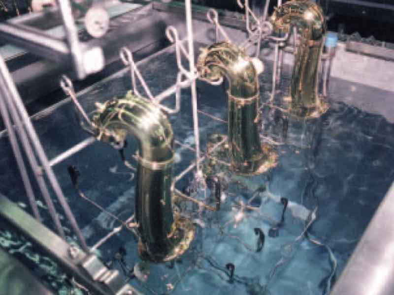 An ultrasonic cleaning system removes polishing compounds from these brass musical instrument components prior to lacquer coating. (Photo courtesy of CAE Blackstone.)