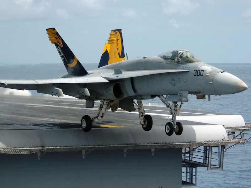 An F/A-18C Hornet launches from the flight deck of the aircraft carrier USS Kitty Hawk.
